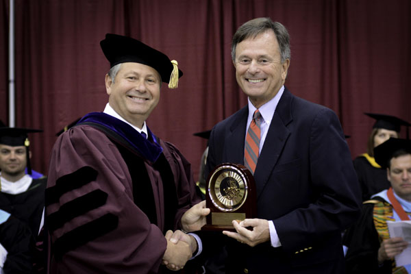 LONG-TIME UNIVERSITY SUPPORTER David Gohn, right, West Plains, received the prestigious Granvil Vaughan Founder's Award during Saturday's Missouri State-West Plains commencement ceremonies at the West Plains Civic Center.  Above, Gohn receives the award from Missouri State-West Plains Chancellor Drew Bennett.  (Missouri State-West Plains Photo)