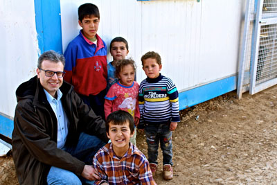 DR. TARIF BAKDASH, kneeling left, a Syrian-American pediatric neurologist who works at Children’s Hospital of Wisconsin, poses with Syrian refugee children in the Za’atari Refugee Camp in Jordan. Bakdash will be in West Plains Feb. 25 to do a live reading and signing of his book, Inside Syria – A Physician’s Memoir: My Life as a Child, a Student, and an MD in an Era of War, as well as participate in a Q and A on the crisis in Syria. (Photo provided)