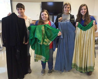 STUDENTS FROM MISSOURI STATE University-West Plains display a few of the traditional clothing items from Central Asia and the Middle East that will be part of the “Journey Through the Mideast and Central Asia” free community reception and fashion show beginning at 5:30 p.m. Feb. 25 in the West Plains Civic Center lobby. The items are on loan from community members who have lived or worked overseas, organizers said, adding the event will cap off the University/Community Programs (U/CP) Department’s February Film Series. With the clothing are, from left, Brandi Snider, Ashton Garner, Hannah Grills and Morgan Kinder, all of West Plains. (Photo provided)