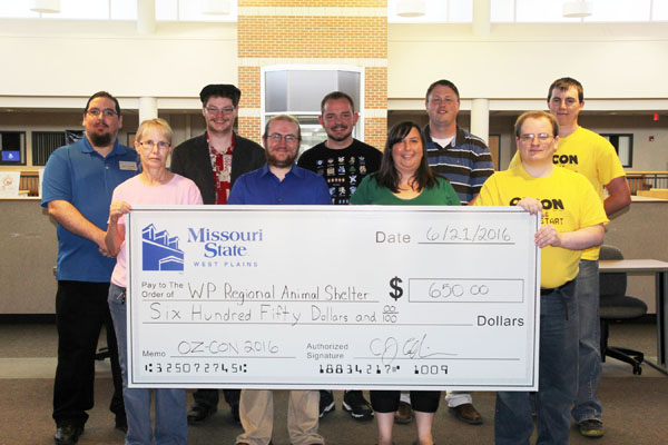 ORGANIZERS OF THE OZARKS GAMING Convention (OzCon) hosted by Missouri State University-West Plains’ Computer Graphics and Programming (CGP) Department and the student chapter of Association for Computer Machinery (ACM) April 29 to May 1 raised $650 for the West Plains Regional Animal Shelter, a non-profit, no-kill animal shelter that’s dedicated to providing loving homes to abandoned animals. On hand for the check presentation were, front row from left, animal shelter manager Trish Hammen; and Biff Bird, Meghan Berry and Mike Scheidt, all of the OzCon planning committee. Back row from left, Jacob Poulette, Jim Listopad, Weston Mitchell, CJ Collins and Ben Bird, all of the OzCon planning committee. (Missouri State-West Plains Photo)