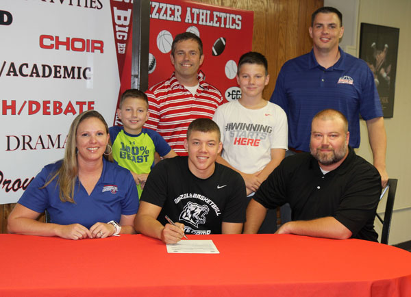 THE GRIZZLY LEGACY is alive and well in the Robbins household as West Plains High School Zizzer basketball standout Christian Robbins today followed in his father’s footsteps and signed a national letter of intent to play basketball for the Missouri State University-West Plains Grizzlies. His father, Jason, played for the Grizzlies from 1994-96. On hand for the signing were, seated from left, Melissa, Christian and Jason Robbins; Christian’s brothers, Clayton and Gunner, behind Christian; and, back row, Zizzer Head Coach Kevin Smith and Grizzly Head Coach Chris Popp. (Missouri State-West Plains Photo)