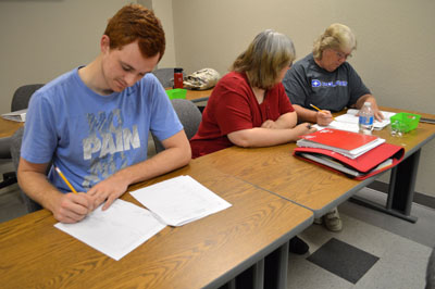 THE COLLEGE READINESS PROGRAM at Missouri State University-West Plains gives prospective students the refresher they need to tackle placement exams and college courses. Above, Math Specialist Elizabeth Nehring, center, helps students Dustin Winslow, left, and Karen Collins, right, both of West Plains. (Missouri State-West Plains Photo)