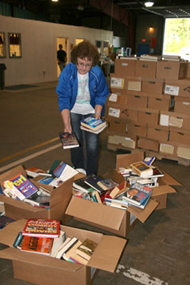 PAULA FORTNER, assistant librarian at Norwood Schools, looks through some of the boxes of books made available to area school districts free of charge through the Christian Appalachian Project’s “Operation Sharing” program. The Corbin, Ky.,-based non-profit organization has teamed up for the past 15 years with Missouri State University-West Plains to provide much needed books and resources to school and public libraries in southern Missouri. (Missouri State-West Plains Photo)