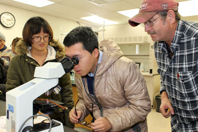 CHINA’S NINGXIA UNIVERSITY students Mingke Liu, left, and Jiawei Zhao, center, examine a grapevine bud in the chemistry lab at Missouri State University-West Plains’ campus in Mountain Grove. The students are studying grape growing and wine making at Missouri State University’s campuses in Springfield and Mountain Grove so they can expand the wine industry in their home province in China. They’re assisted above by Randy Stout, field crew leader with Missouri State University’s Fruit Experiment Station in Mountain Grove. (Missouri State-West Plains/Mountain Grove Campus Photo)
