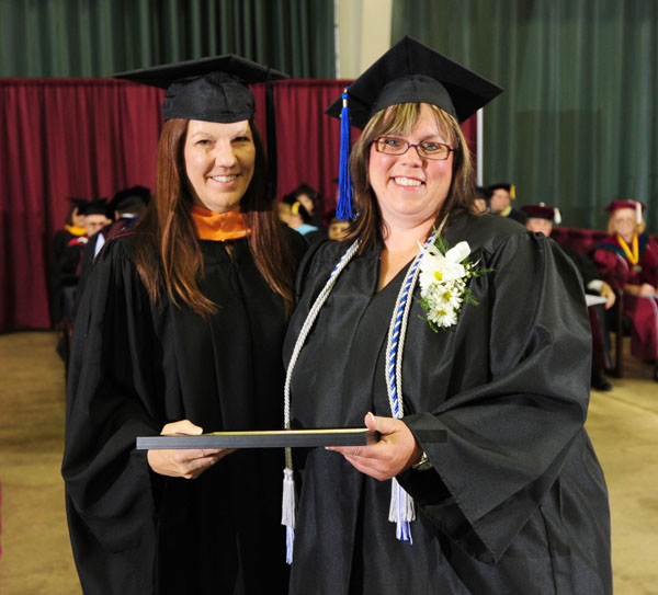 KIM GRISHAM, right, West Plains, received the Missouri League of Nursing’s Outstanding Student Award for Associate of Science in Nursing degree graduates at Missouri State University-West Plains commencement ceremonies Saturday, May 19, at the West Plains Civic Center. The award recognizes a graduate from the ASN program who exhibits exceptional leadership potential, interpersonal skills and continuing professional growth. Grisham will receive a one-year membership to the MLN. She received her award from Barbara Caton, director of the nursing department. (Missouri State-West Plains Photo)