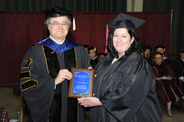 LACY MILL, West Plains, received the Outstanding Student Award for Associate of Arts/Associate of Applied Science degree graduates at Missouri State University-West Plains’ commencement ceremonies Saturday, May 18, at the West Plains Civic Center. The award recognizes a graduate from either the AA or AAS programs who exhibits academic excellence, interest and enthusiasm in learning, conscientiousness, academic honesty, a willingness to participate and help others in class, and exceptional university and community service. Mill graduated with an Associate of Arts in General Studies, Associate of Applied Science in Child and Family Development and Bachelor of Science in Child and Family Development degrees during Saturday’s commencement. She received her award from Dean of Academic Affairs Dr. Christopher Dyer. (Missouri State-West Plains Photo)