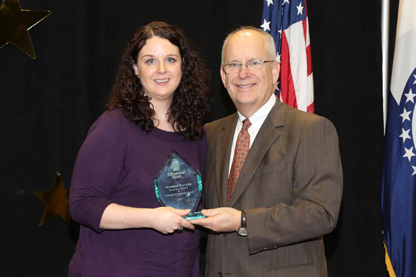 JENNIFER WALKER, who was promoted from financial aid counselor to financial aid coordinator at Missouri State University-West Plains on Jan. 1, received a Staff Excellence in University Service Award during the annual Staff Service Awards program Jan. 11 at Missouri State University in Springfield. The award is given to full-time staff members “who have made significant contributions to the university community. They strive to do their jobs well on a daily basis, go above and beyond the call of duty in a special situation and have contributed in a significant way to the success of the university.” Above, Walker receives a personalized plaque and $1,500 cash award from Missouri State University System President Clif Smart. (Missouri State-West Plains Photo)