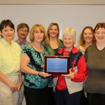 THE STAFF of Missouri State University-West Plains’ student services department won the “Highest Dollar Amount Raised” award in the departmental contest at the university’s 19th annual auction April 5. This is the fourth consecutive year the department has won the award. On hand for the plaque presentation were, front row from left, Drago College Store Manager Kathy Schloss, Food Services Manager Mozella Jett, Career Services Assistant Coordinator Alice Smith, and Financial Aid Clerk Becky Craig; back row: Dean of Student Services Dr. Herb Lunday, Coordinator of Student Life & Development Rogers Taylor, Registrar Shanna Dale, Coordinator of Admissions Melissa Jett and Grizzly Basketball Head Coach Yancey Walker. (Missouri State-West Plains Photo)