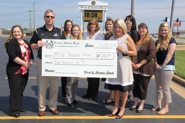 WOOD & HUSTON BANK recently joined more than 80 businesses, organizations and individuals who showed their support for the Carol Silvey Student Union by offering donations for its construction inside Hass-Darr Hall on the Missouri State University-West Plains campus. Community Bank President Angie Menz and several of her staff members presented the $5,000 check to Missouri State-West Plains Joe Kammerer. From left are bank representative Ashley Young, Kammerer, bank representatives Brittany Smith, Christina Painter, Sheila Stoops, Belinda Kuntz, Menz, Branch Manager/Mortgage Lender Karen Eggert, Andy Tripp and Cari Rainwater. (Missouri State-West Plains Photo)