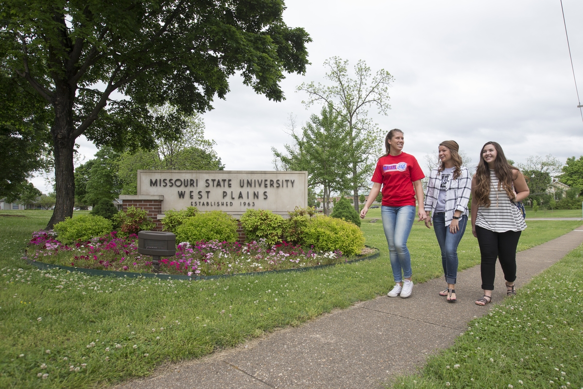 Students walking near Missouri State University-West Plains sign.