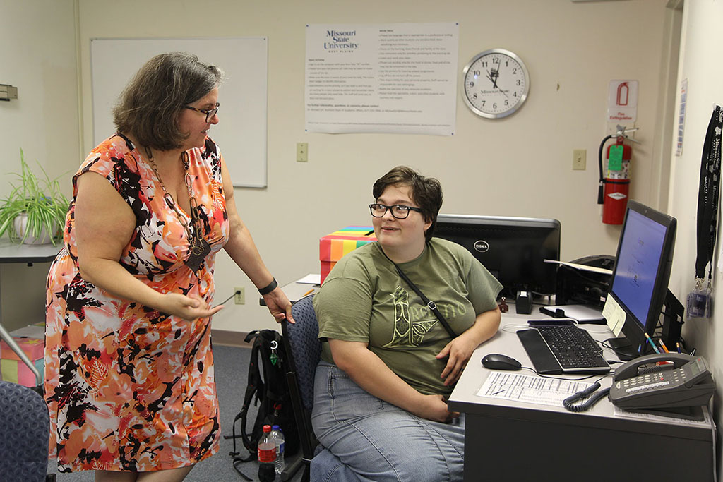 TUTORS PROVIDED through the Corps of Opportunity Program are essential to the smooth operation of the Writing Lab, according to Writing Specialist Alexandra Graham, who speaks with Corps tutor Billie Randle, Thayer, seated. (Missouri State-West Plains Photo)