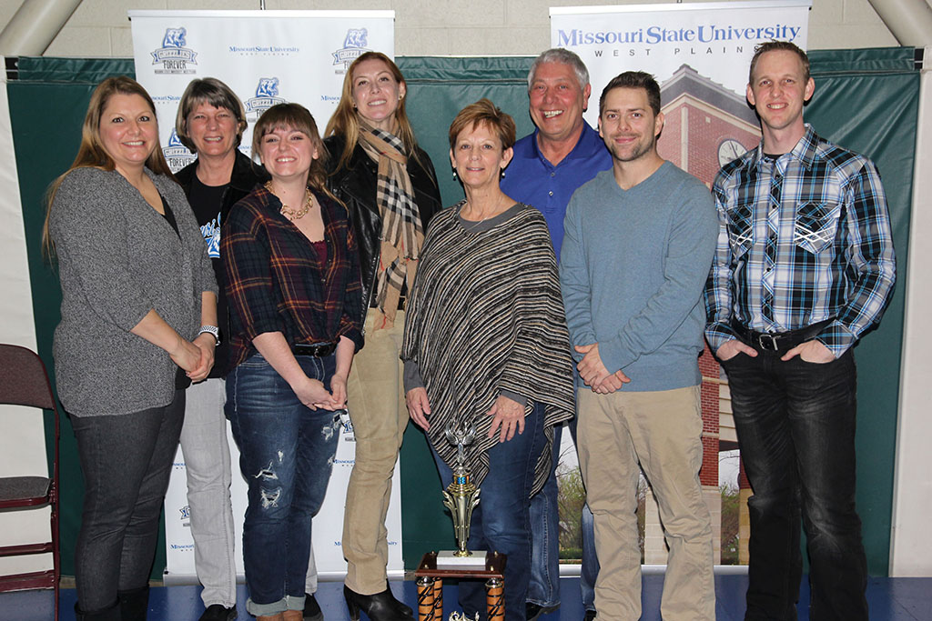 A GROUP OF MISSOURI STATE University-West Plains employees and friends took top honors in the 15th annual Trivia Night benefitting Grizzly Athletics at Missouri State University-West Plains Jan. 27 at the West Plains Civic Center. With the traveling trophy, which is awarded to the first place team, are members, from left, Keri Elrod, Sally Robinson, Eryn Walters, Bronwen Madden, Brenda Polyard, Jack Bates, Kris Bates and Mark Lewis.  (Missouri State-West Plains Photo)
