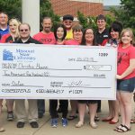 On hand for the check presentation were, front row from left, Christos House Executive Director Moiria Seiber, and OzCon board members Mike Scheidt, Dalyn Bird, Amber Switzer, Meghan Berry, Amber Carr, Breanna Lane and Biff Bird. Back row: Jacob Poulette, CJ Collins, Sarah Corniels, Will Mahan, Jim Listopad and Ben Bird. (Missouri State-West Plains Photo)