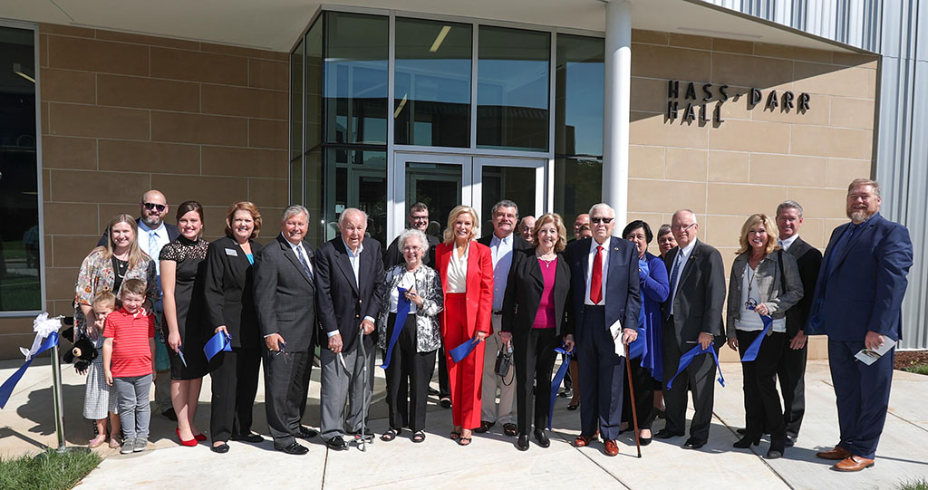 Dignitaries line up outside to cut the ribbon for the Hass-Darr Hall grand opening.