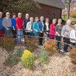 Members of the Friends of the Garnett Library stand in a row near the entrance of the library.