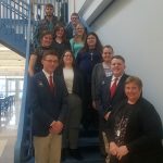 Students are standing by rows on a staircase