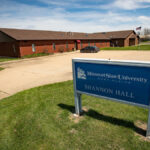 A building in the background with a blue sign in the foreground that says "Missouri State University-West Plains Shannon Hall"