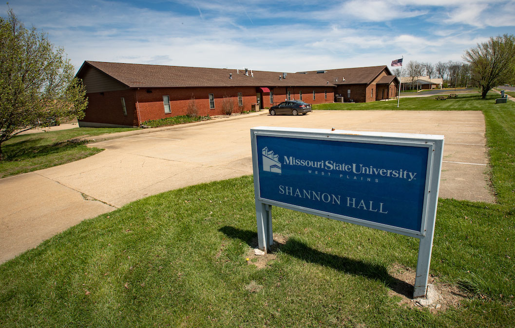 A building in the background with a blue sign in the foreground that says "Missouri State University-West Plains Shannon Hall"