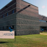 Building exterior with a banner in the yard that says "ASCEND"