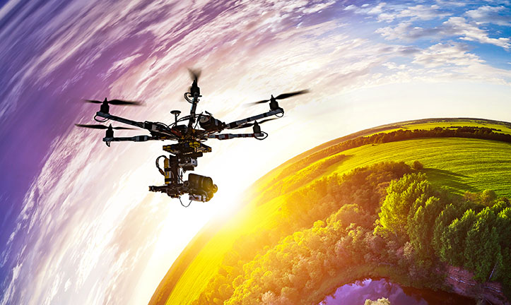 Drone with professional cinema camera flying over a blue calm river in the forests and fields at the sunset. Hexacopter drone with high resolution digital camera on the sky. Little planet effect.