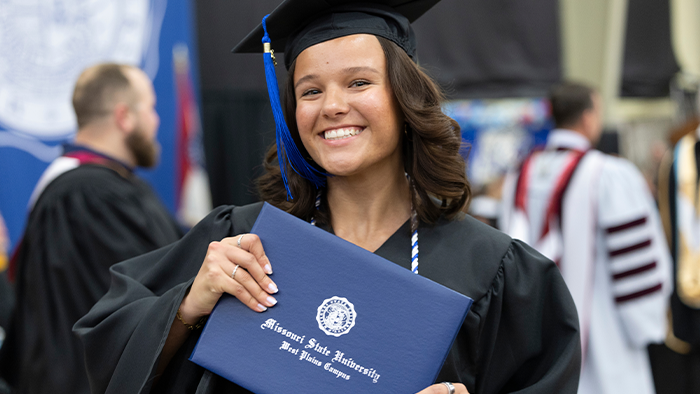 Student holds their diploma signifying the finish line