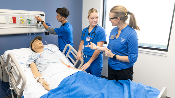 nursing students work with an instructor in the simulation lab