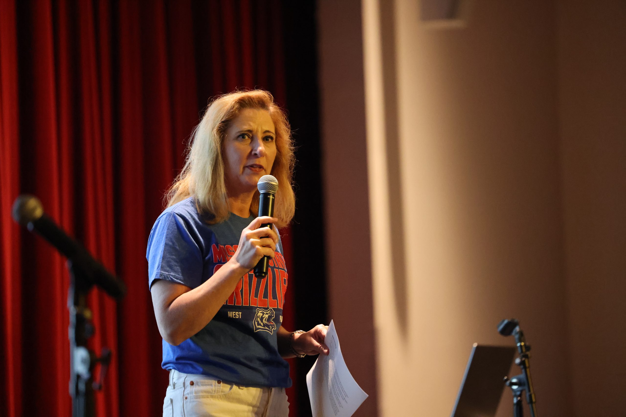 Chancellor Zora Mulligan holds a mic on the stage of the West Plains Civic Center