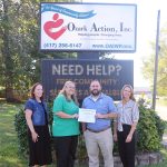 Shawna Hammon and Trevor Cressman pose for a group photo in front of the Ozark Action, Inc. sign with Ozark Action employees Holly Tucker and Angie Kinder